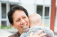 Woman with moko kauae holding a baby.